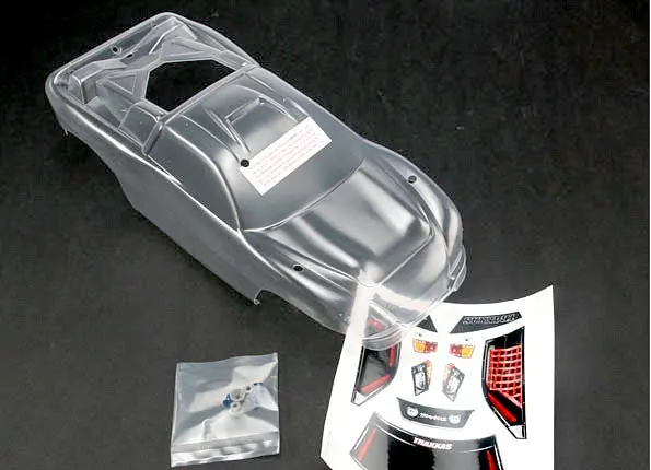 Traxxas 4412 - Body, Nitro Rustler® (Clear, Requires Painting)/Window, Grille, Lights Decal Sheet/ Wing And Aluminum Hardware 1